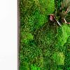 Close-up of vibrant green moss wall art featuring textured foliage and leaf accents in a dark frame
