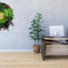 Round botanical moss wall clock hanging on a gray wall in a modern office interior with a desk