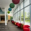 Colorful round reindeer moss balls in red, green, and blue hanging from the ceiling in a modern hall