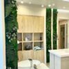 Vertical moss and fern wall panel accent installed in a modern bathroom beside vanity mirror