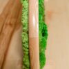 Close-up edge view of a double-sided moss table divider with a natural wood frame on a tabletop.