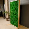 Tall wooden room divider with vibrant green textured moss, standing in a modern room.