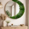 Round moss wall mirror with natural wood frame mounted above a wooden console table in a modern room