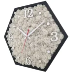Hexagonale Wanduhr mit schwarzem Rahmen, weißem Islandmoos und silbernen Ziffern