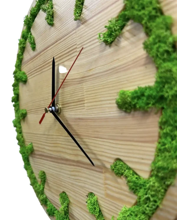 Round wooden wall clock with green moss inlaid around the rim and black clock hands.