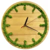 Round wooden wall clock with carved hour markers filled with green moss and black hands.