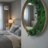 Round natural wood wall mirror accented with green moss and plants, mounted on a gray wall