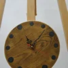 Round wooden wall clock with prominent grain, dark circular epoxy markers, black hands, and a red second hand