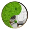 Round framed wall mirror with preserved moss in a yin-yang design reflecting an interior room