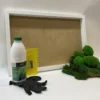 DIY moss kit with white wooden frame, adhesive bottle, yellow spatula, gloves, and green ball and flat moss.