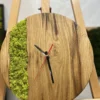 Close-up of round wood wall clock featuring green preserved moss and black hands with a red second hand