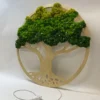 Side angle of round wooden tree wall art with textured green moss canopy and white power cord