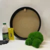 Round black frame for DIY wall art with green ball moss, adhesive bottle, yellow notched spreader, and gloves.