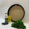 Round DIY moss art kit with black frame, adhesive bottle, yellow spreader comb, black gloves, and clumps of green moss
