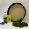Round black frame with DIY moss kit accessories including glue bottle, scraper, black gloves, and green moss clumps.