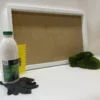 White frame with green moss clump, adhesive bottle, yellow notched spreader, and black work gloves
