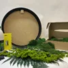 Round DIY moss wall art kit contents including circular frame, craft glue, spatula, gloves, and preserved greenery.