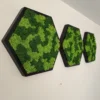 Trio of black hexagon reindeer moss wall art panels mounted in a row on an interior wall