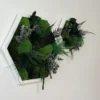 Hexagon moss wall art in white wooden frame with preserved green ball moss and ferns hanging on a white wall