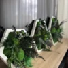Row of hexagon moss art frames with preserved green ball moss and ferns displayed on a light wooden tabletop