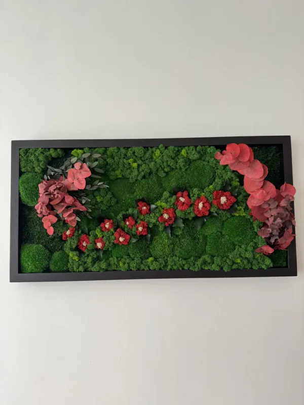 Preserved moss wall art with floral accents and foliage in a rectangular frame.