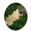 Round mirror with black frame bordered by green moss and preserved fern plants