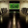 meeting-room-map-lite2.jpg Illuminated green moss world map wall art mounted in a conference room above a long dark boardroom table.