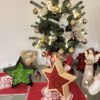 Wooden Christmas stars filled with green and red reindeer moss on a festive table display with a small Christmas tree.