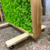 Side angle of green moss room divider with natural wood frame on caster wheels
