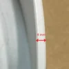 Close-up of white frame rim showing 4 mm edge thickness measurement