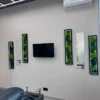 Vertical moss wall art with black frames and integrated lighting installed alongside mirrors in a modern room.