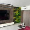 Multi-toned preserved moss accent wall next to a slatted wood TV panel in a modern living room