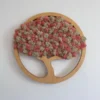 Round wooden tree wall art with preserved moss foliage on a white wall