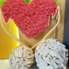 Red and pink reindeer moss heart in a wooden embrace frame, displayed above decorative wooden sphere accents.
