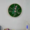 Round moss wall art with pink roses and white branches in natural wood frame mounted on a wall above a vanity