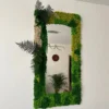 Rectangular wall mirror framed with preserved moss and botanical foliage.