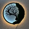 Illuminated round Tree of Life moss dryad wall art glowing on a textured wall