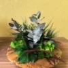 Wooden bowl centerpiece with preserved moss, ferns, and botanical foliage.