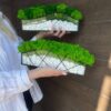 Two glass planters with green preserved moss and white pebbles featuring wave and geometric wire designs.