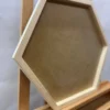 Side angle of an empty natural wood hexagon frame for moss wall art displayed on an easel