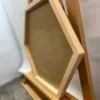 Angled side view of natural wood hexagon frame showing depth and backing on an easel
