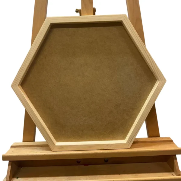 Hexagonal shadow box frame with recessed backing board resting on a wooden easel