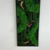 Vertical moss wall art panel with green bun moss, preserved foliage, and wood accents in a black frame