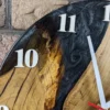 Close-up of oak wall clock with pearlescent black epoxy resin river, natural wood grain, and white numerals