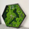 Oblique view of hexagonal wall clock with mixed green preserved moss, black frame, and raised hour markers