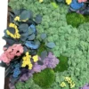 Close-up of preserved wall art detailing green reindeer moss, round ball moss, eucalyptus, and yellow blooms
