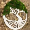 Round white tree of life wall art with green moss foliage and pine cones on a textured bark background