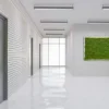 Rectangular green reindeer moss wall panel mounted in a bright modern office corridor.