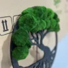 Side angle of round black wooden tree wall art highlighting dimensional green ball moss clumps.