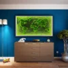 wall-416060-1-1-1200x675.jpg-1 Framed green moss world map on a blue wall above a wooden cabinet flanked by two tall bookcases.